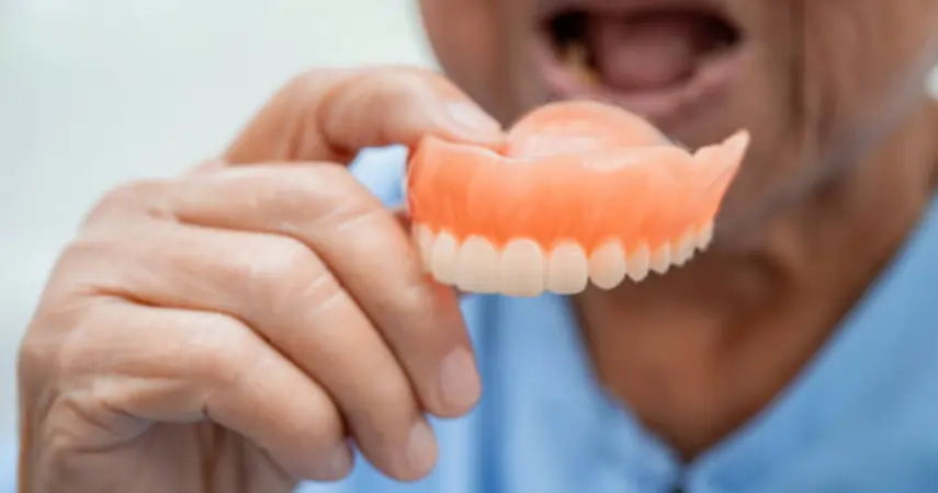 Senior patient looking frustrated with loose dentures